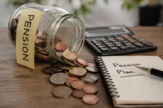 A tipped-over jar labelled Pension spilling coins across a desk beside a calculator and a notebook headed Pension Plan